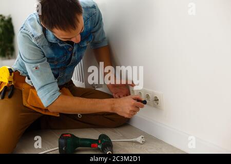 Electrician checking socket voltage with digital multimeter Stock Photo