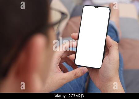 Close up image of smart phone mockup, casual man relaxing and holding phone with white screen template Stock Photo