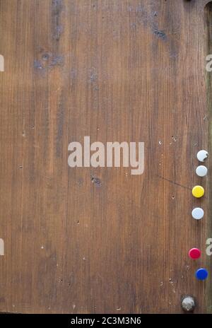 Vertical high angle shot of colorful pins on a wooden surface Stock Photo