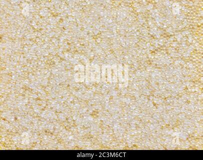 Transparent silica gel on yellow background; silica gel is desiccant used in industrial, moisture protection Stock Photo