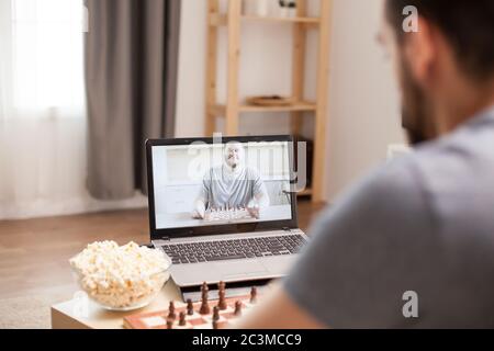 Friends talking and playing chess on video call during quarantine. Stock Photo