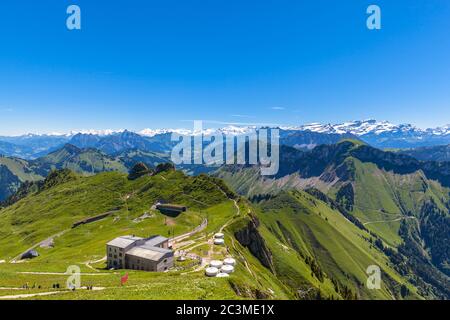 Panorama view of Bernese Alps from top of Rochers-de-Naye, with the cogwheel train station in foreground, near Montreux, Canton of Vaud, Switzerland Stock Photo