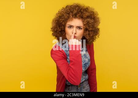 This is lie! Portrait of angry woman with fluffy curly hair touching nose, showing liar gesture, expressing distrust of false suggestion, deception. i Stock Photo