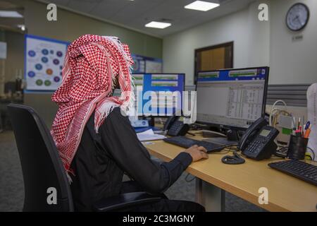 picture from back for Saudi man working in the office wearing a shemagh Stock Photo