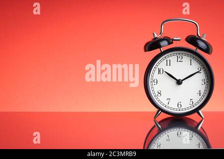 Alarm Clock on red background with selective focus and crop fragment. Business and Copy space concept Stock Photo