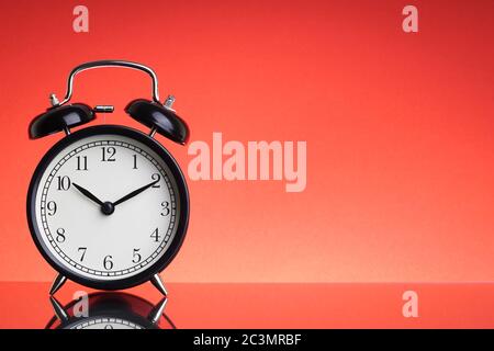 Alarm Clock on red background with selective focus and crop fragment. Business and Copy space concept Stock Photo