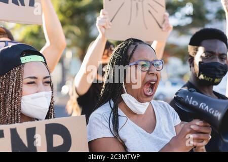 Group of people demonstrators protest in city street against racism - Equal rights fighting and black lives matter campaign concept - Focus on african Stock Photo