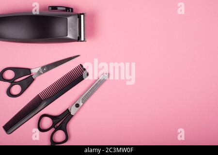 hairdressing hair cutting tools on a pink background top view, copy space. Stock Photo