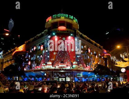 Thuong Xa Tax, the classic Saigon department store with Christmas decorations and shoppers in the street on December 22, 2010 in Ho Chi Minh City. Stock Photo