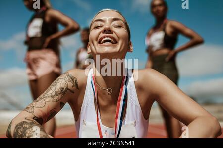 Track-and-field athletics. Young Caucasian woman, professional athlete,  runner training at public stadium, sport court, outdoors. Concept of sport,  achievment, motion. Stock Photo