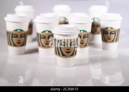 Starbucks cups - Starbucks drink cup - Starbucks takeway cups - Starbucks take away cups on a white light table Stock Photo