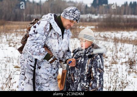 hunter with his son on winter hunting Stock Photo