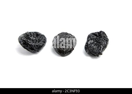Prunes, three dry plums isolated on white background. Set of dried fruits Stock Photo