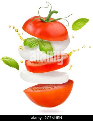 slices of tomato, mozzarella cheese and basil flying on white background Stock Photo