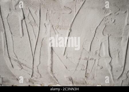 Gray uneven wall of background or texture with spots and lines from the trowel or spatula. Close up uneven plaster surface texture background. Wall ba Stock Photo