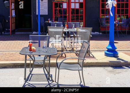 Phoenixville, PA, USA - June 14, 2020: Socially distanced tables are appropriately positioned along the main street in the town. Stock Photo