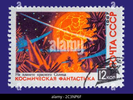 Vintage cancelled postage stamp from the Soviet Union circa 1967. Colourful stamp of a space scene. Set on a dark blue folder. Stock Photo