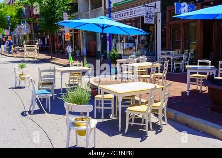 Phoenixville, PA, USA - June 14, 2020: Socially distanced tables are appropriately positioned along the main street in the town. Stock Photo