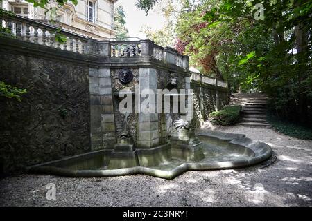 Le Port-Marly, France - June 24, 2018: Old stone fountain with sculptures (dragon pool) near The Chateau de Monte-Cristo is a house museum of the writ Stock Photo