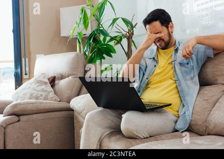 Photo of a handsome Hispanic man using a laptop - communication, leisure, and people concept Stock Photo