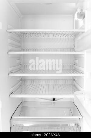 Defrosted refrigerator without food. Empty open white fridge. Stock Photo