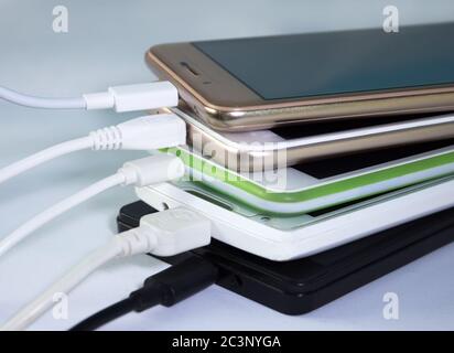 A pile of smartphones, charging through usb cables Stock Photo