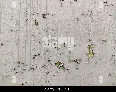 Cracked paint on an old wall with yellow and green colors and flows Stock Photo