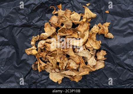 dry mushrooms on textured black crumpled paper. healthy eating concept Stock Photo