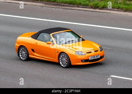 2008 orange MG TF; Vehicular traffic moving vehicles, cars driving vehicle on UK roads, motors, motoring on the M6 motorway highway Stock Photo