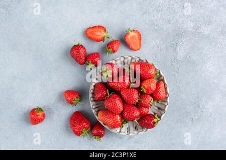 Strawberries on concrete background with copy space for text. Home grown organic strawberries, summer berry harvest Stock Photo