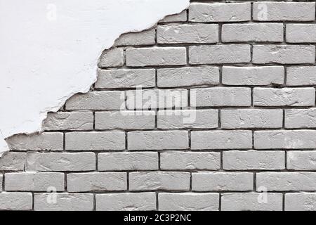 Texture of an old white brick wall with old stucco in the upper left corner. Background of silicate brick in the form of brick masonry, copy space. Stock Photo