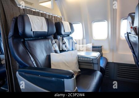 Large blue leather-covered aircraft business-class seat in a narrow-body commercial aircraft Stock Photo