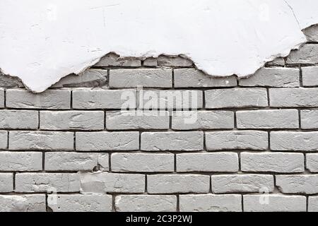Texture of an old white brick wall with old weathered torn stucco at the top. Background of silicate brick in the form of brickwork, copy space. Stock Photo