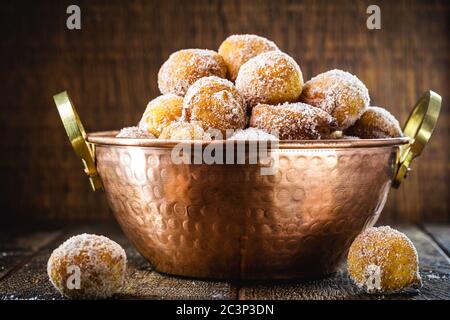 Brazilian sweet called Bolinho de Chuva, made with cinnamon, refined and fried sugar. Food served in a copper pot, typical sweet from minas gerais and Stock Photo