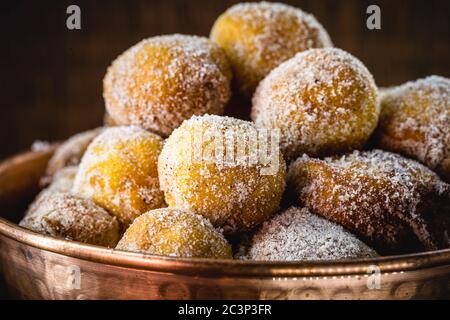 Brazilian sweet called Bolinho de Chuva, made with cinnamon, refined and fried sugar. Food served in a copper pot, typical sweet from minas gerais and Stock Photo