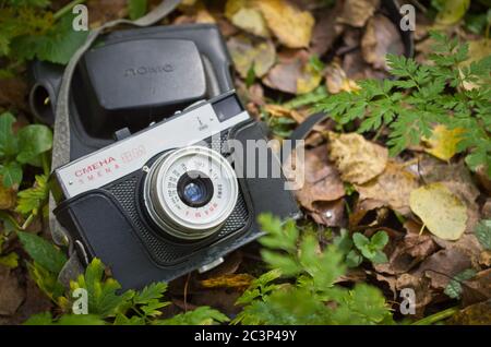 The old Soviet camera Smena 8M in the autumn forest. Stock Photo