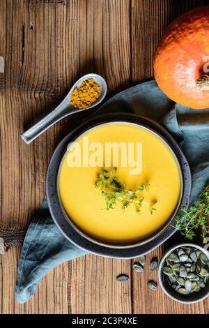 Healthy dish, delicious vegan creamy red lentil and pumpkin soup topped with fresh thyme Stock Photo