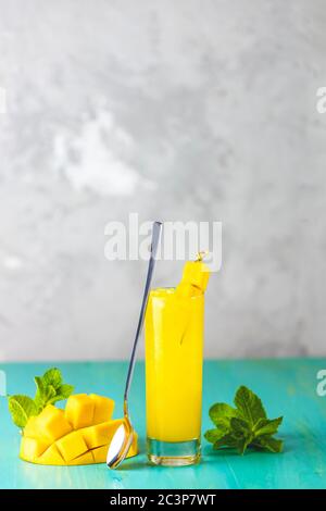 Refreshing summer cocktails made of mango, cold drink or a drink with ice on a blue gray background. Fresh summer ice cold mango cocktail or juice wit Stock Photo