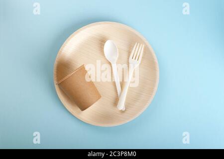 A set of disposable plate, disposable cup, fork and spoon on light blue background Stock Photo