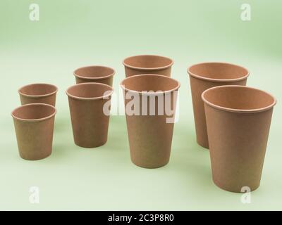 Paper cups on a green background. Different sizes. Stock Photo