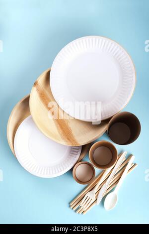 Eco friendly disposable tableware flat lay on light blue background.  Stock Photo