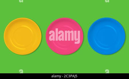 Orange, red and blue plate on a green background. Colorful empty food plates. Fashionable creative and summer style. Minimal design. Flat layout, top Stock Photo