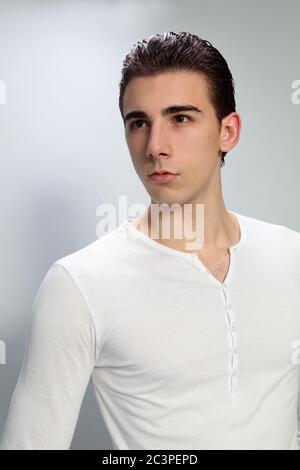 Attractive male model with short hair posing in studio on isolated background. Style, trends, fashion concept. Stock Photo