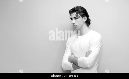 Attractive male model with short hair posing in studio on isolated background. Style, trends, fashion concept. Stock Photo