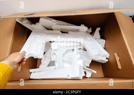 Man hand holding multiple waste inside cardboard containing Polystyrene the synthetic aromatic hydrocarbon polymer made from the monomer known as styrene Stock Photo