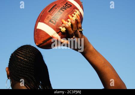 MIAMI - MARCH 23, 2019: A young woman with long fingernails plays American football at a Spring Break party on South Beach. Stock Photo