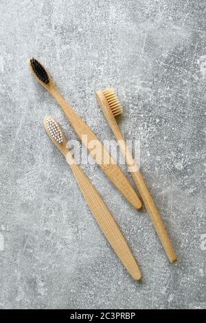 Eco-friendly bamboo toothbrushes on concrete stone background. Natural organic bathroom beauty product concept. Flat lay, top view. Stock Photo