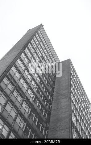 Vertical low angle greyscale shot of a tall building captured during the day Stock Photo