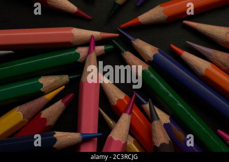 The large group of colored pencils on the black floor Stock Photo