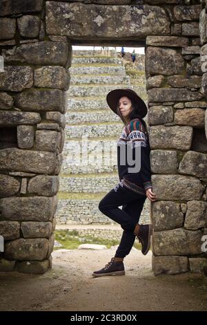Girl posing at the lost old Inca city Machu Picchu in the Andes ...